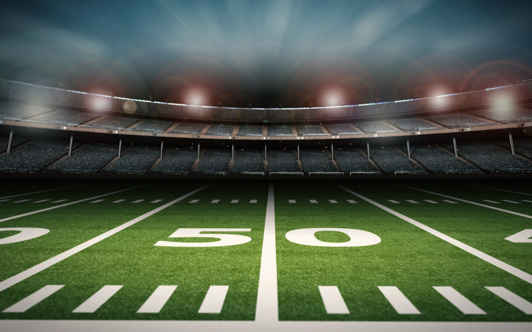 Football stadium at the 50-yard line under stadium lights